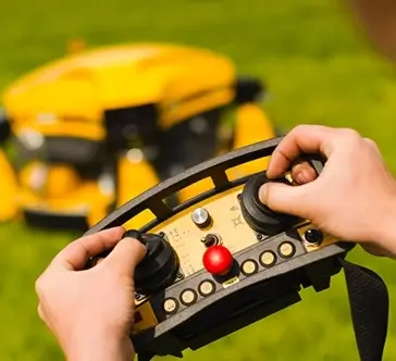 Closeup of Person Practicing Lawnmower Safety by Operating a Spider Slope Mower Using a Remote Control